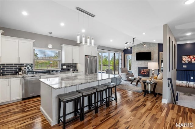 1547 Frost Lndg, Columbia, IL 62236 - kitchen featuring stainless steel appliances, healthy amount of natural light, white cabinets, wood finished floors, and vaulted ceiling