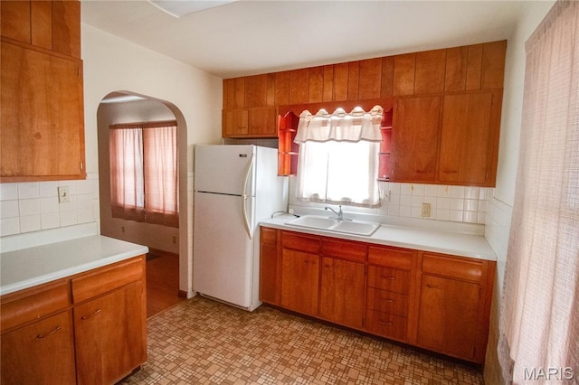 703 Condit Ave, Alton, IL 62002 - kitchen with freestanding refrigerator, a sink, light countertops, and tasteful backsplash