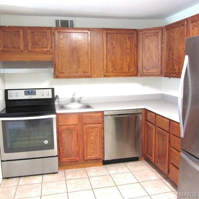2840 Blackforest Dr Unit B, Saint Louis, MO 63129 - kitchen with stainless steel appliances, a sink, wall chimney exhaust hood, light countertops, and brown cabinetry