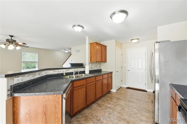 457 Spring Trce, Ofallon, MO 63368 - kitchen featuring stainless steel appliances, a ceiling fan, decorative backsplash, dark countertops, and a peninsula