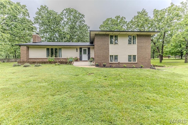 20193 SW Oakwood Dr, Lebanon, MO 65536 - split level home featuring brick siding, a front yard, and a chimney