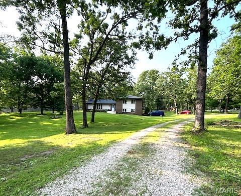 20193 SW Oakwood Dr, Lebanon, MO 65536 - view of property's community featuring driveway, a yard, and view of wooded area