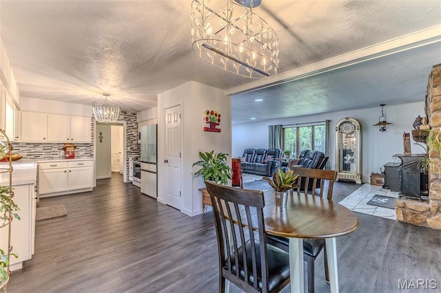 20193 SW Oakwood Dr, Lebanon, MO 65536 - dining area featuring a chandelier, a textured ceiling, a wood stove, and dark wood-style flooring
