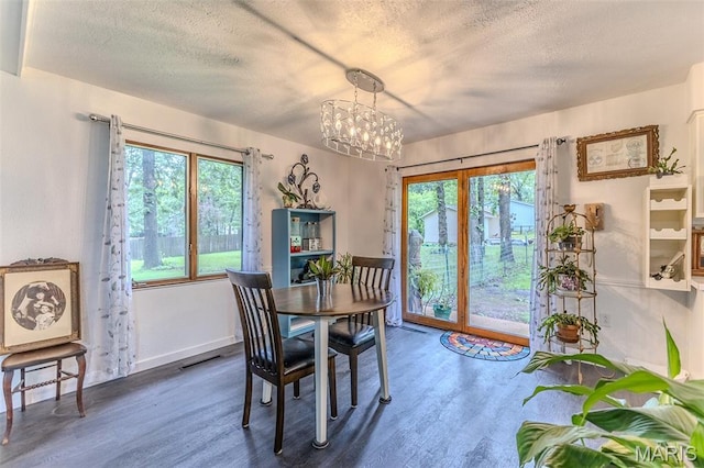 20193 SW Oakwood Dr, Lebanon, MO 65536 - dining area featuring a textured ceiling, wood finished floors, a chandelier, and baseboards