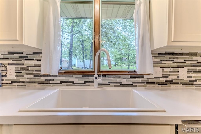20193 SW Oakwood Dr, Lebanon, MO 65536 - kitchen view of a sink, white cabinetry, tasteful backsplash, and light countertops
