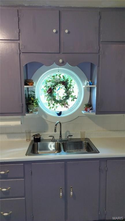 1500 Perryville Rd, Cape Girardeau, MO 63701 - kitchen featuring a sink, gray cabinetry, light countertops, and backsplash