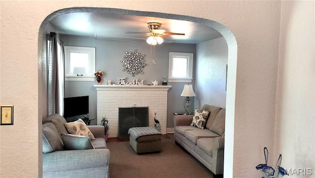 1500 Perryville Rd, Cape Girardeau, MO 63701 - living area featuring arched walkways, a textured wall, a brick fireplace, and a ceiling fan