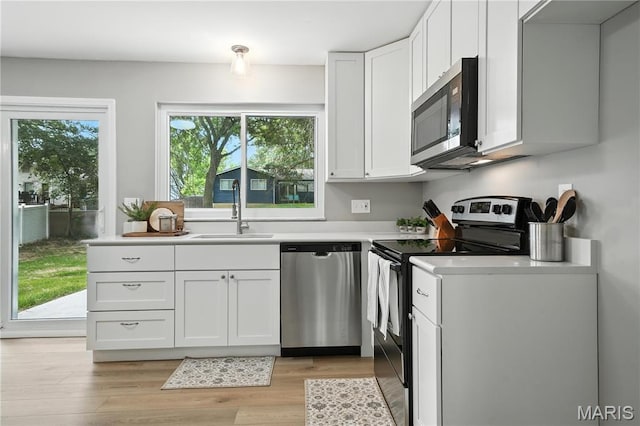 208 Mill Run Ln, Saint Peters, MO 63376 - kitchen with appliances with stainless steel finishes, light countertops, white cabinetry, and light wood-style floors