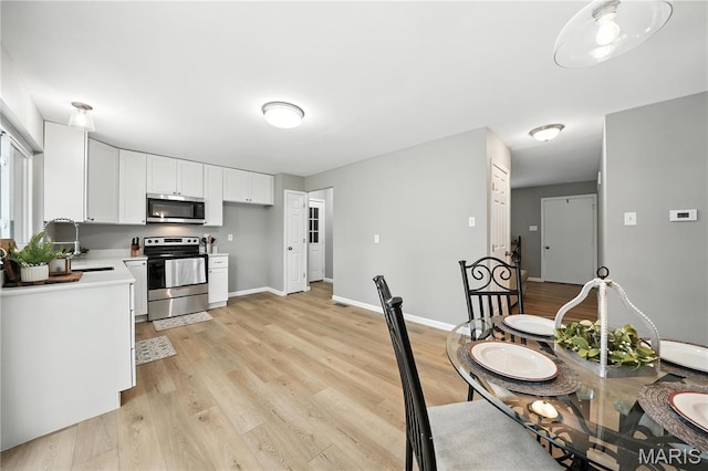 208 Mill Run Ln, Saint Peters, MO 63376 - kitchen with appliances with stainless steel finishes, light countertops, white cabinets, and light wood-style flooring