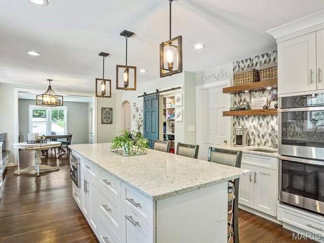 201 Banner St, Edwardsville, IL 62025 - kitchen featuring stainless steel appliances, a barn door, open shelves, a center island, and white cabinets