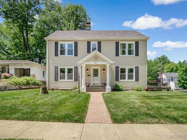 201 Banner St, Edwardsville, IL 62025 - colonial home featuring a front lawn and a chimney