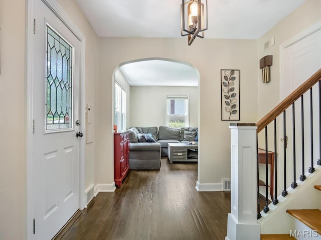 201 Banner St, Edwardsville, IL 62025 - entryway featuring arched walkways, dark wood-style floors, baseboards, stairs, and a chandelier