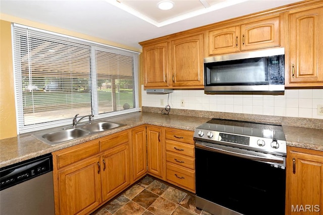 12713 Partridge Run Dr, Florissant, MO 63033 - kitchen featuring stainless steel appliances, a sink, backsplash, brown cabinets, and stone finish floors