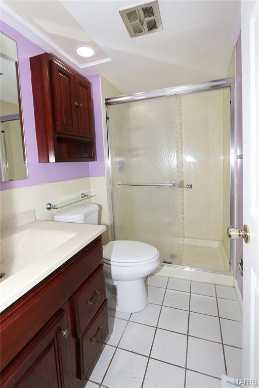 12713 Partridge Run Dr, Florissant, MO 63033 - full bathroom featuring vanity, tile patterned flooring, toilet, and a shower stall