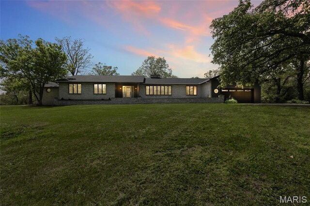 509 Saint Francois Rd, Bonne Terre, MO 63628 - rear view of house featuring an attached garage, a lawn, and brick siding