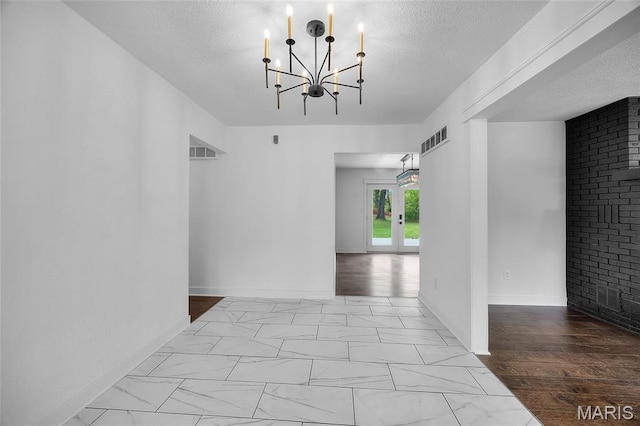 509 Saint Francois Rd, Bonne Terre, MO 63628 - hallway featuring a chandelier, a textured ceiling, marble look tile flooring, and baseboards
