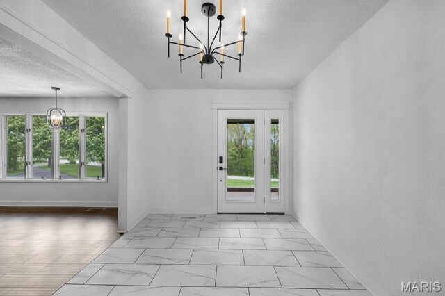 509 Saint Francois Rd, Bonne Terre, MO 63628 - entrance foyer with a chandelier, plenty of natural light, a textured ceiling, marble finish flooring, and baseboards
