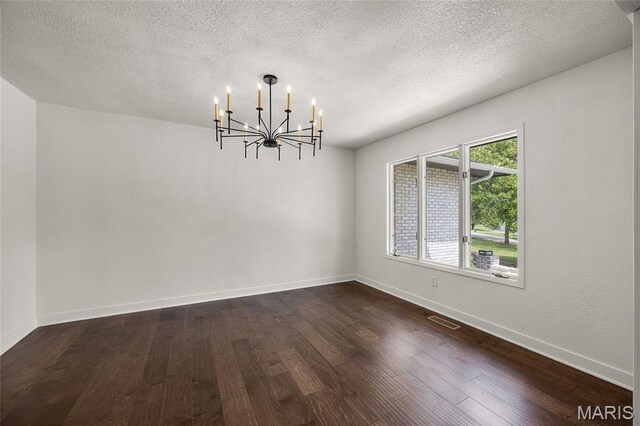 509 Saint Francois Rd, Bonne Terre, MO 63628 - empty room with a chandelier, dark wood-type flooring, a textured ceiling, and baseboards