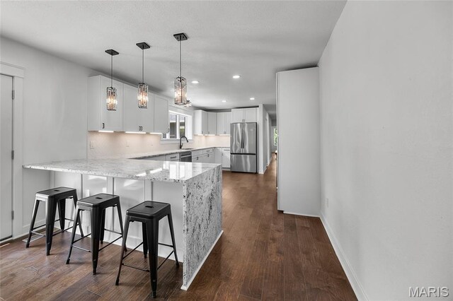 509 Saint Francois Rd, Bonne Terre, MO 63628 - kitchen featuring stainless steel appliances, a peninsula, light stone countertops, a kitchen bar, and white cabinetry
