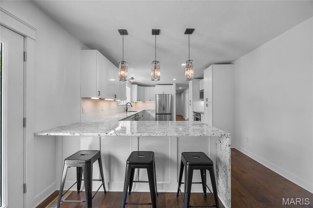 509 Saint Francois Rd, Bonne Terre, MO 63628 - kitchen featuring freestanding refrigerator, a peninsula, a sink, light stone counters, and recessed lighting