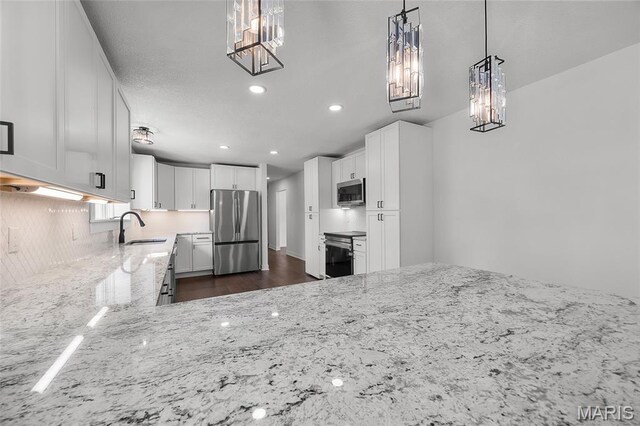 509 Saint Francois Rd, Bonne Terre, MO 63628 - kitchen featuring appliances with stainless steel finishes, a sink, a chandelier, light stone countertops, and white cabinetry
