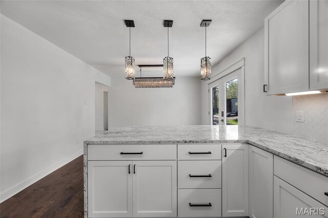 509 Saint Francois Rd, Bonne Terre, MO 63628 - kitchen with dark wood-style flooring, baseboards, a peninsula, light stone counters, and a textured ceiling