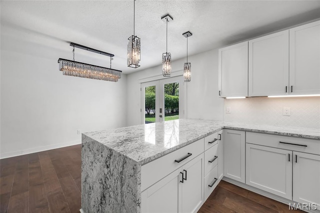 509 Saint Francois Rd, Bonne Terre, MO 63628 - kitchen with a peninsula, light stone countertops, white cabinetry, french doors, and a textured ceiling