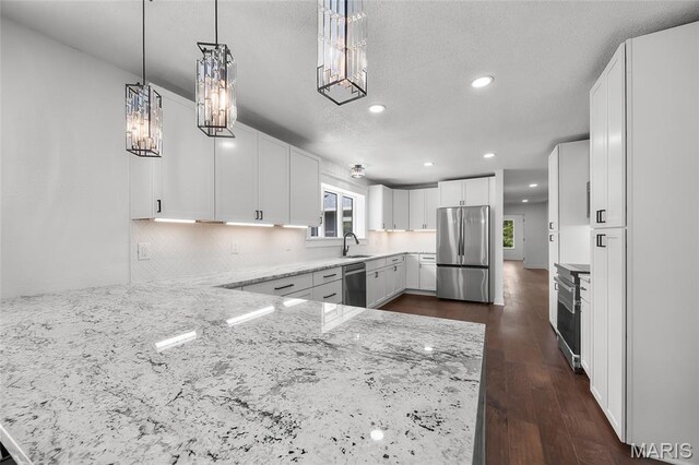 509 Saint Francois Rd, Bonne Terre, MO 63628 - kitchen with stainless steel appliances, light stone countertops, recessed lighting, white cabinets, and a peninsula