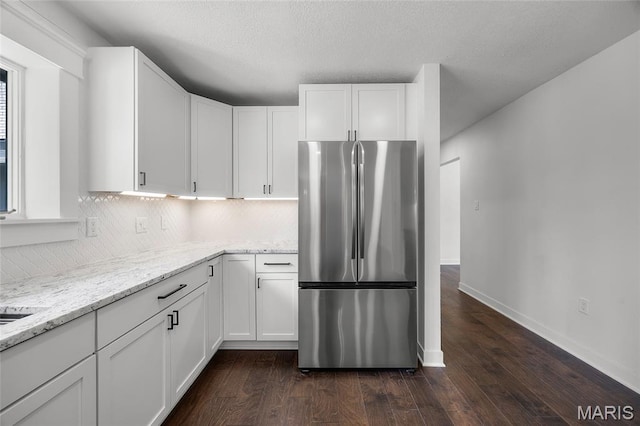 509 Saint Francois Rd, Bonne Terre, MO 63628 - kitchen featuring freestanding refrigerator, light stone counters, tasteful backsplash, white cabinetry, and a textured ceiling