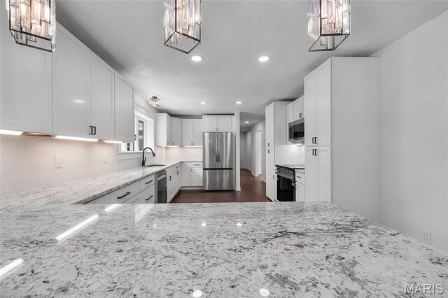 509 Saint Francois Rd, Bonne Terre, MO 63628 - kitchen with stainless steel appliances, light stone countertops, a chandelier, tasteful backsplash, and recessed lighting
