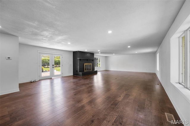 509 Saint Francois Rd, Bonne Terre, MO 63628 - unfurnished living room featuring dark wood finished floors, recessed lighting, a brick fireplace, a textured ceiling, and baseboards