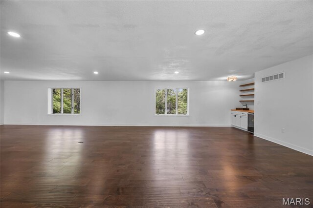 509 Saint Francois Rd, Bonne Terre, MO 63628 - unfurnished living room featuring healthy amount of natural light, recessed lighting, dark wood finished floors, baseboards, and a sink