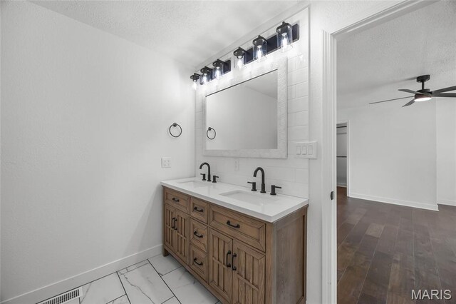 509 Saint Francois Rd, Bonne Terre, MO 63628 - full bath with baseboards, double vanity, a ceiling fan, and a textured ceiling