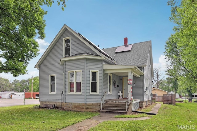 1618 N State St, Litchfield, IL 62056 - view of front facade with a front yard, a shingled roof, a chimney, solar panels, and a gate