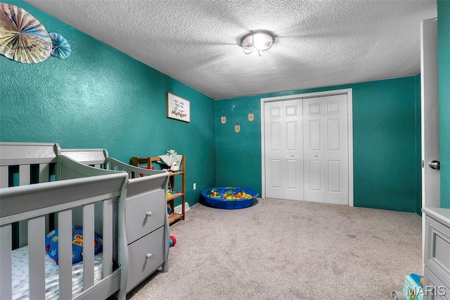 1407 Perry Ave, Cape Girardeau, MO 63701 - carpeted bedroom featuring a closet, a textured ceiling, a textured wall, and a nursery area