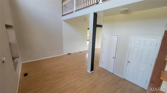 5714 Maple Ave, Saint Louis, MO 63112 - spare room featuring light wood-style floors, a high ceiling, and baseboards