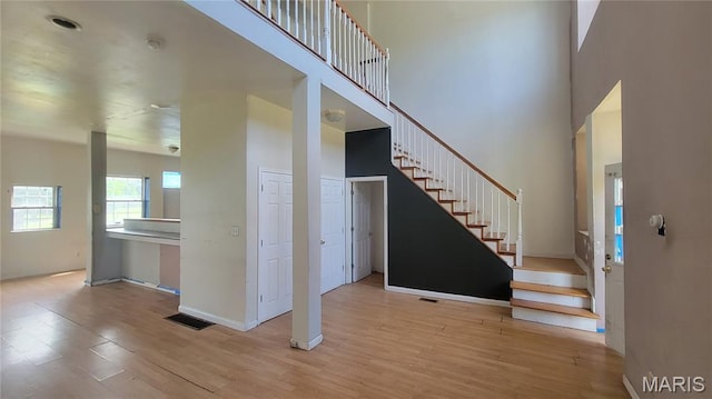 5714 Maple Ave, Saint Louis, MO 63112 - stairs featuring a high ceiling, wood finished floors, and baseboards