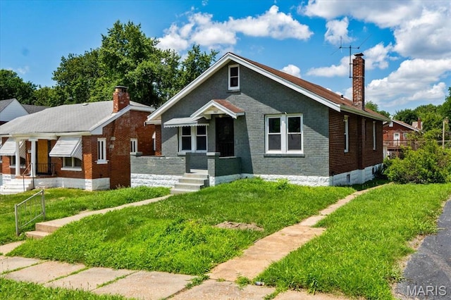 3807 Lawler Dr, Northwoods, MO 63121 - bungalow featuring a chimney, brick siding, and a front lawn