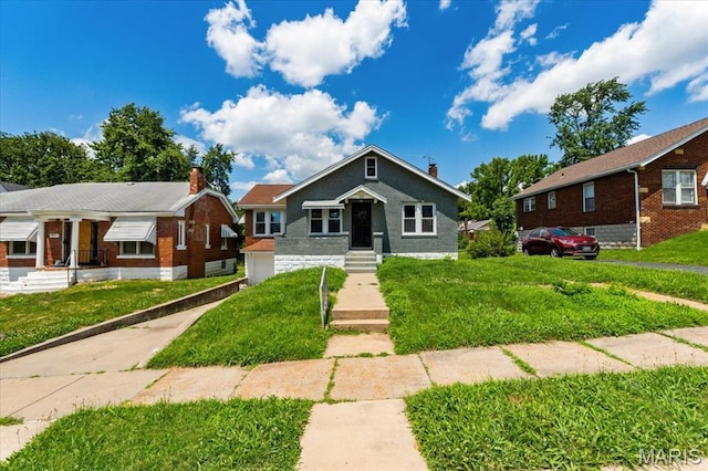 3807 Lawler Dr, Northwoods, MO 63121 - view of front facade featuring a front lawn, a garage, and brick siding