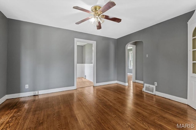 3807 Lawler Dr, Northwoods, MO 63121 - unfurnished room featuring arched walkways, a ceiling fan, and wood finished floors