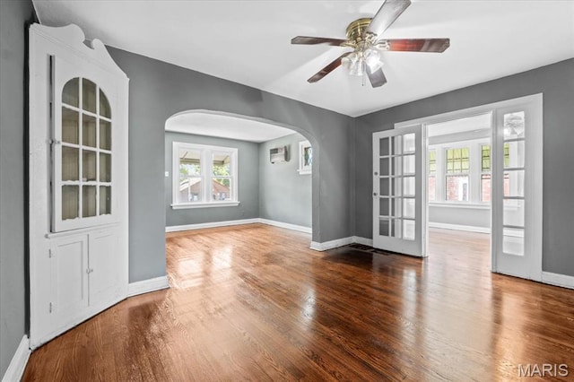3807 Lawler Dr, Northwoods, MO 63121 - empty room featuring arched walkways, wood finished floors, a ceiling fan, and an AC wall unit