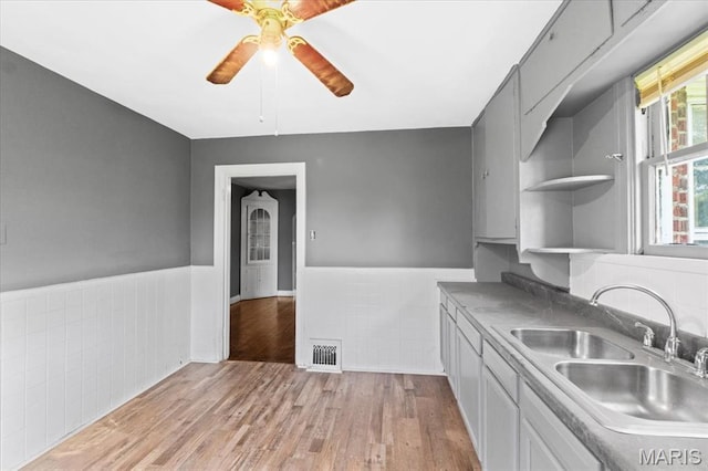 3807 Lawler Dr, Northwoods, MO 63121 - kitchen featuring wainscoting, open shelves, tile walls, a ceiling fan, and light wood-style floors