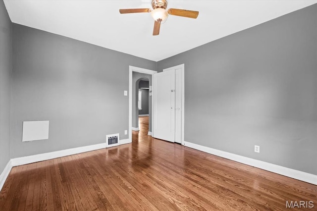 3807 Lawler Dr, Northwoods, MO 63121 - spare room with arched walkways, wood finished floors, and a ceiling fan