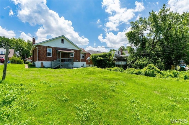 3807 Lawler Dr, Northwoods, MO 63121 - back of house featuring brick siding, a chimney, and a yard