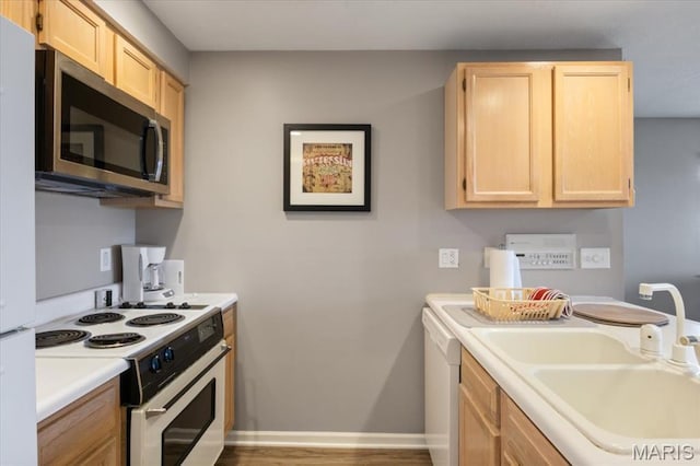 33 Monterey Dr Unit 2A, Lake Ozark, MO 65049 - kitchen featuring white appliances, light brown cabinetry, a sink, light countertops, and baseboards