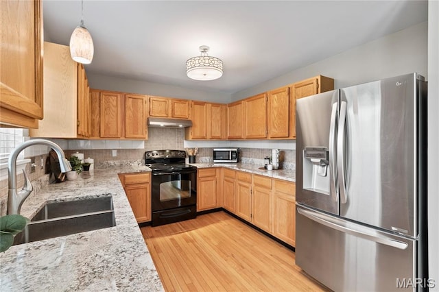 668 Top Notch Ln, Eureka, MO 63025 - kitchen with stainless steel appliances, a sink, under cabinet range hood, backsplash, and light wood-type flooring