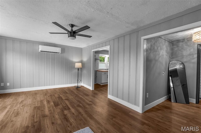 500 Frisco Rd, Campbell, MO 63933 - unfurnished room featuring a wall mounted AC, ceiling fan, wood finished floors, a textured ceiling, and baseboards
