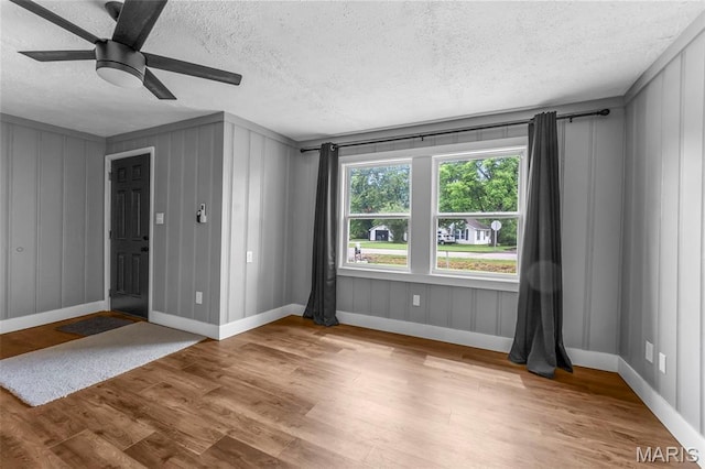 500 Frisco Rd, Campbell, MO 63933 - empty room featuring a textured ceiling, wood finished floors, a ceiling fan, and baseboards