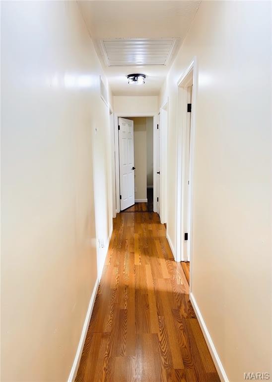 11630 Carolview Dr, Florissant, MO 63033 - hall featuring wood finished floors, attic access, and baseboards