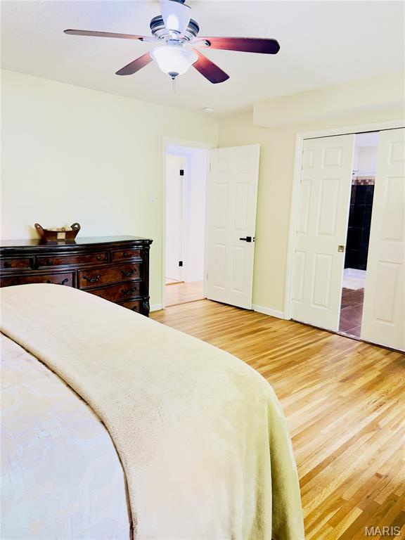 11630 Carolview Dr, Florissant, MO 63033 - bedroom featuring light wood finished floors, ceiling fan, and baseboards